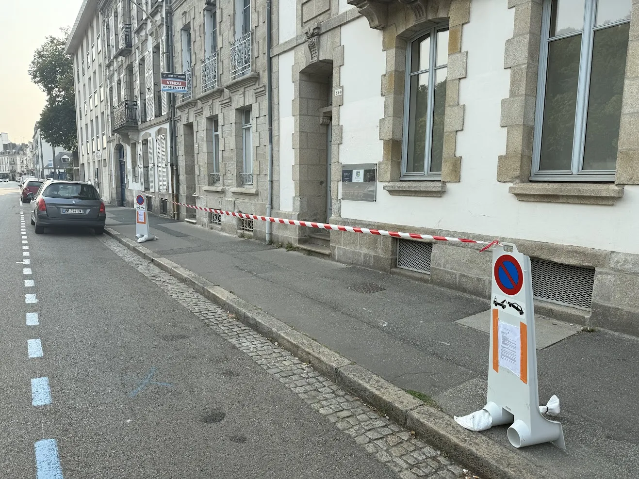 Places neutralisées devant un immeuble en travaux.